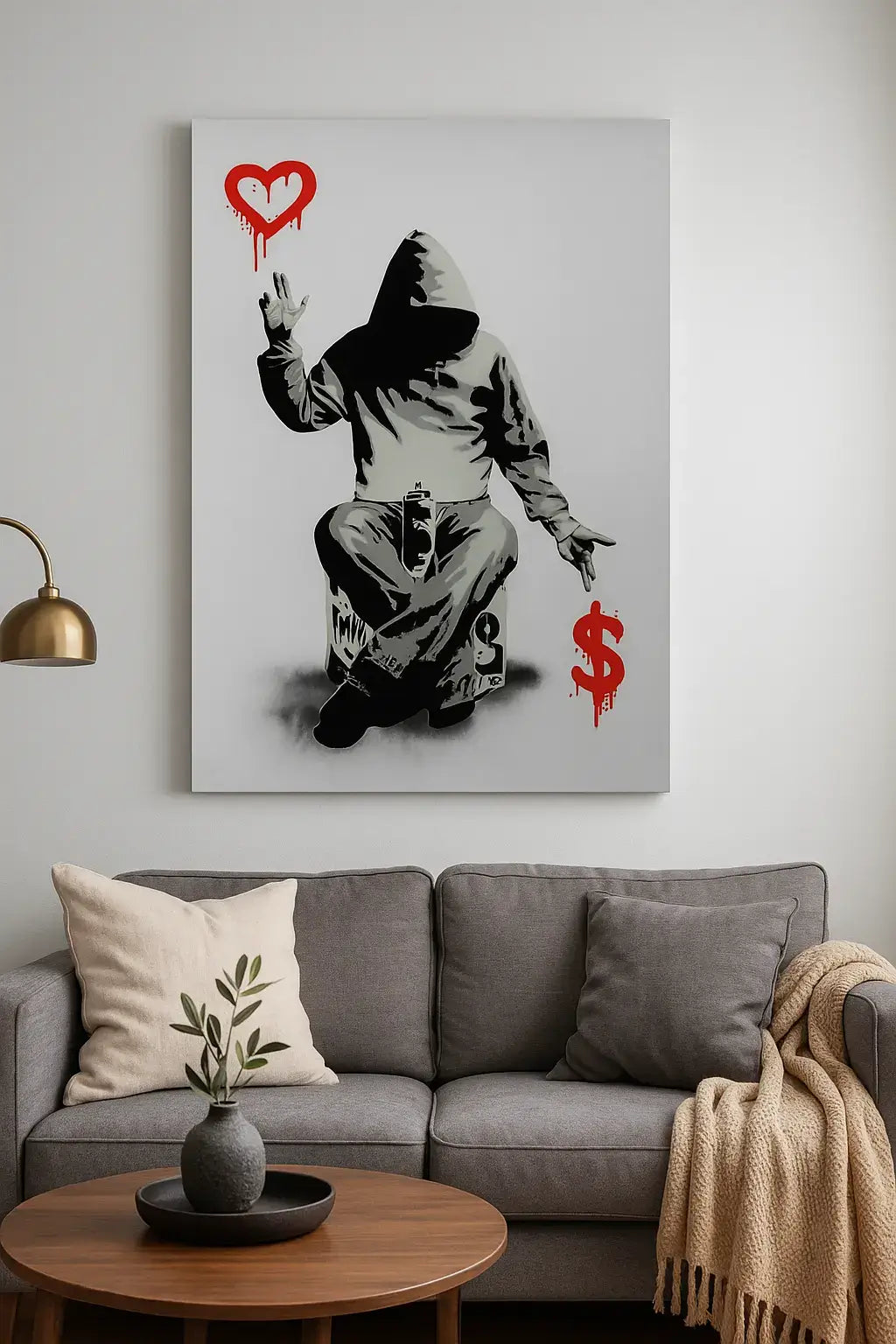 Canvas print of a hooded figure with a heart and dollar sign on a wall above a sofa.