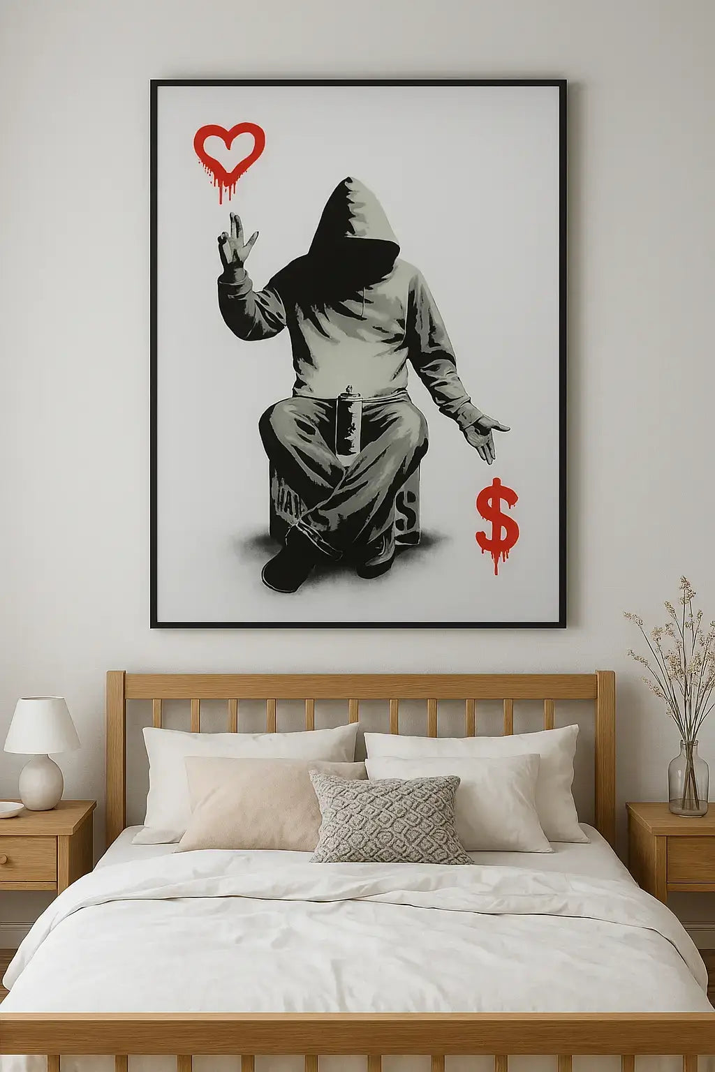 Framed artwork of a hooded figure with a heart and dollar sign on a wall above a bed.