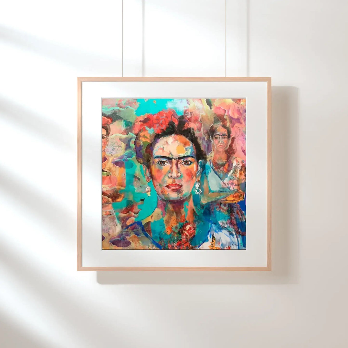 Framed artwork of a colorful portrait on a white wall