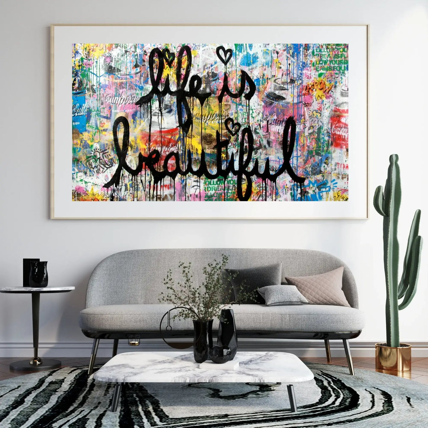 Colorful abstract art print with 'Life is Beautiful' on a wall above a gray sofa.