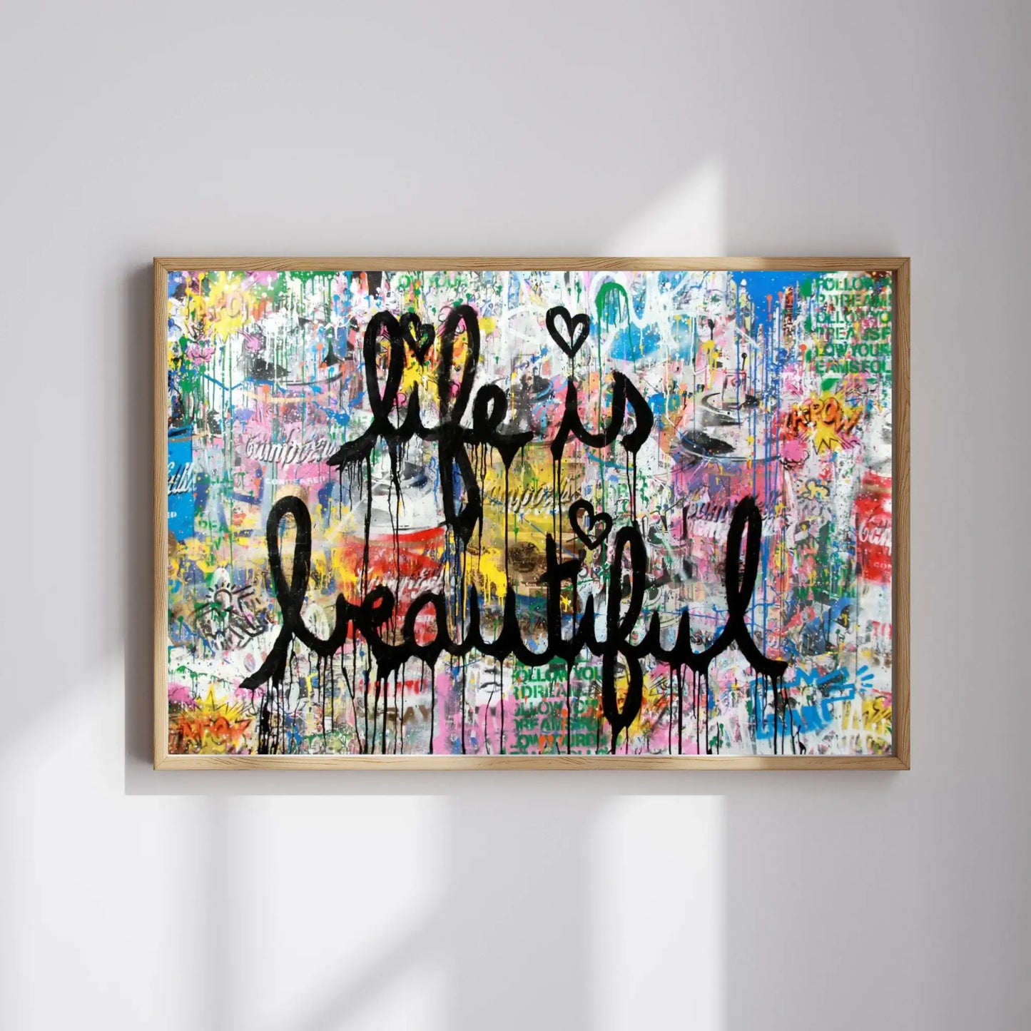 Framed colorful artwork with 'Life is Beautiful' text on a white wall