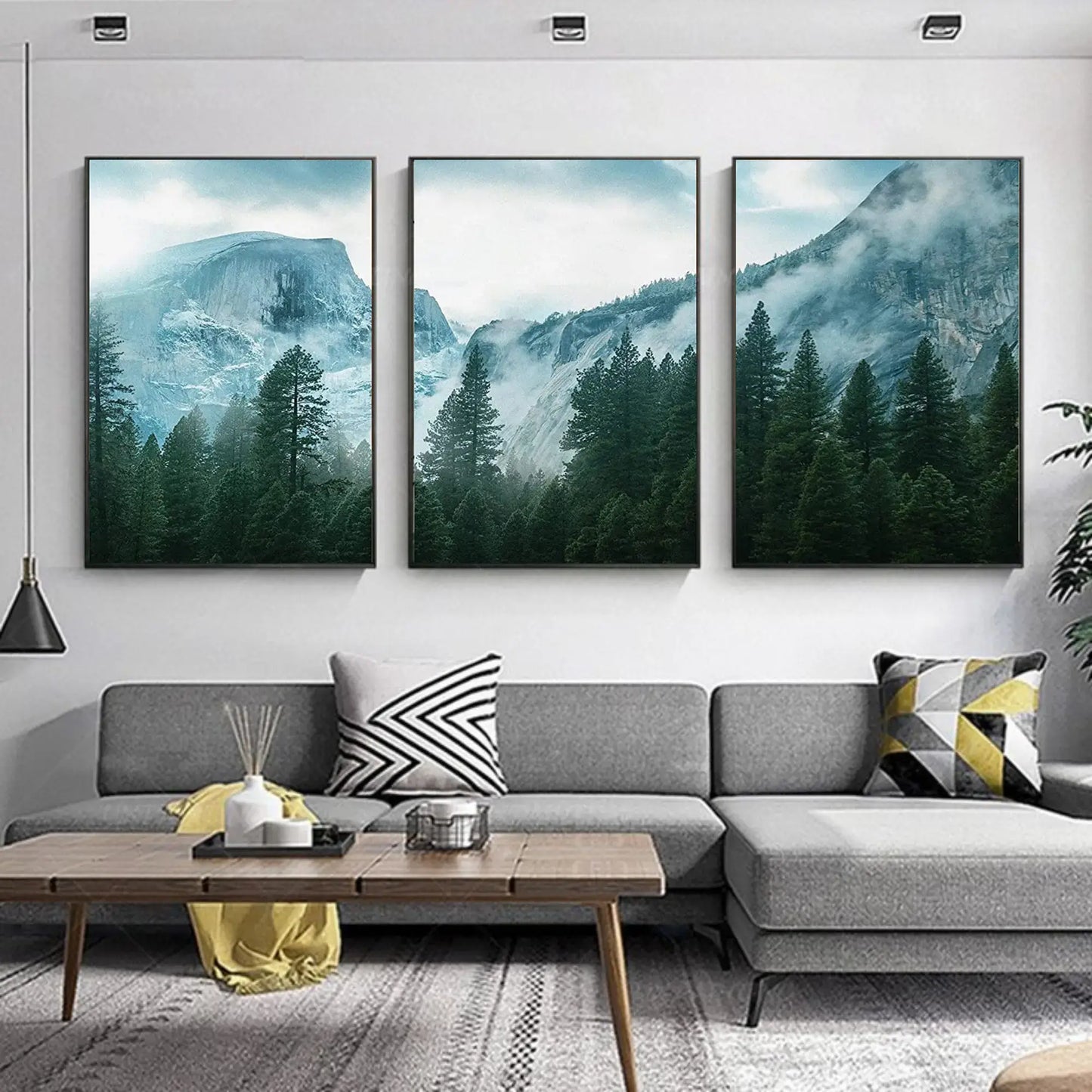 Living room with a gray sofa, wooden coffee table, and three mountain-themed wall art pieces.