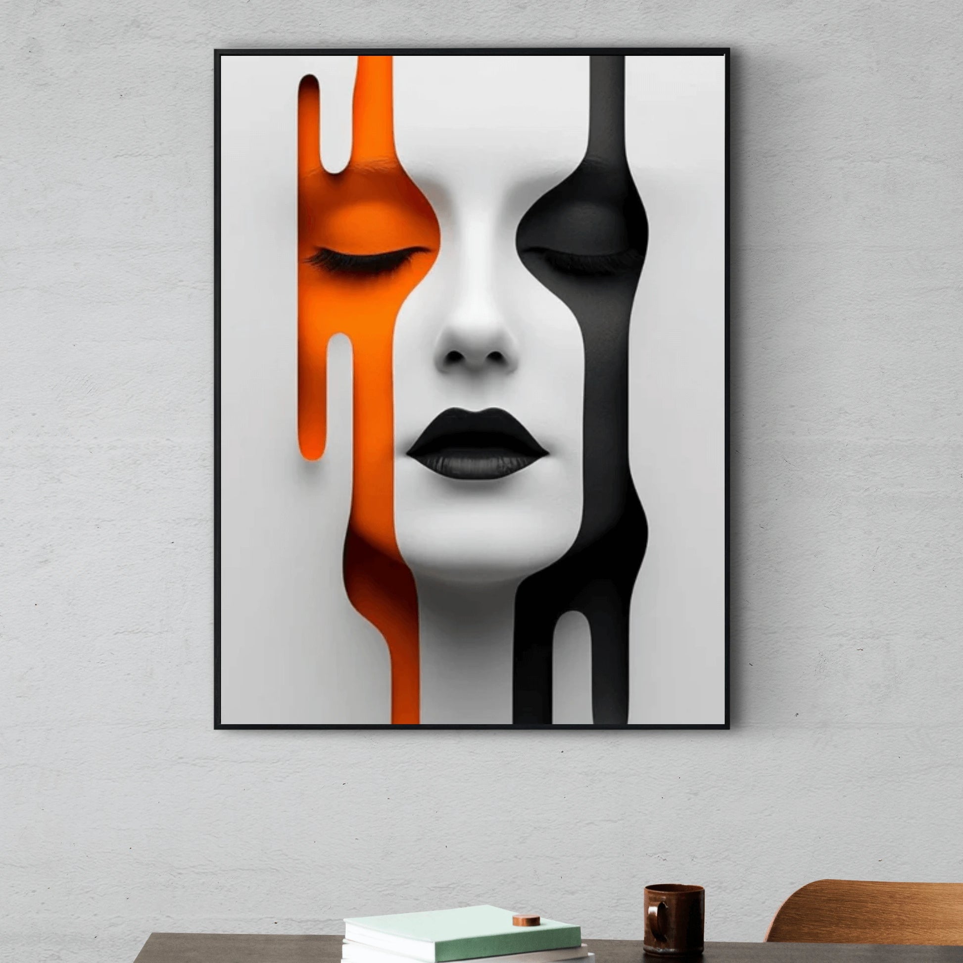Abstract art print of a face with orange, black, and white colors on a gray wall.