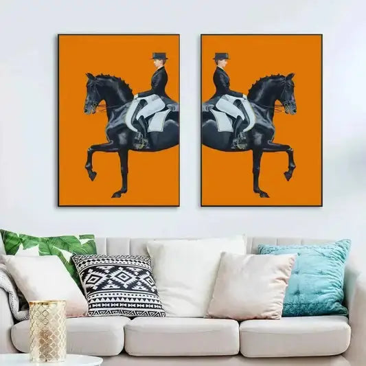 Two canvas prints paintings of a person riding a horse on an orange background above a white sofa with colorful pillows.