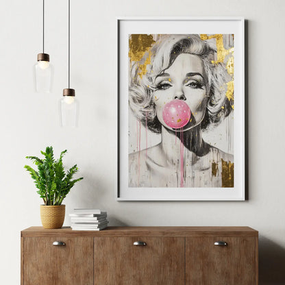 Framed artwork of a stylized portrait with a pink bubble gum on a wall above a wooden cabinet.
