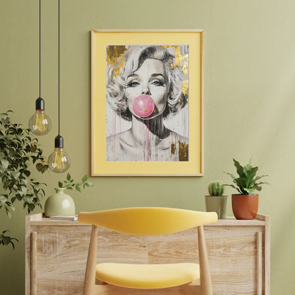 Framed artwork of a woman blowing a pink bubble gum bubble on a green wall with a yellow chair and wooden cabinet.