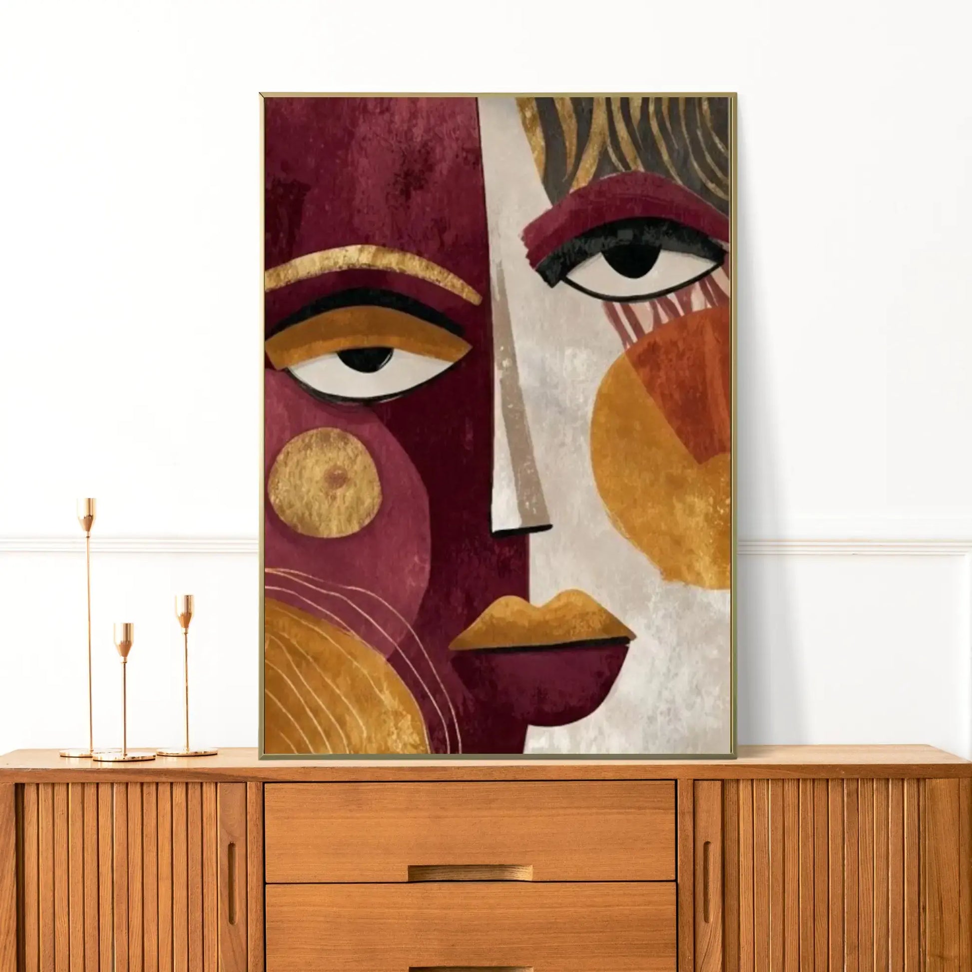 Modern abstract wall art featuring a split portrait of a face with cubist and boho influences. The left side is deep burgundy with a large stylized eye and gold geometric circles. The right side is warm beige with an eye, abstract gold and ochre shapes, and prominent gold lips. This luxury canvas print is ideal for contemporary living room wall decor.