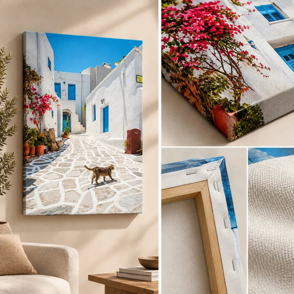A wall art print/canvas showing a Mediterranean-style street with white buildings, blue doors and windows, bright pink flowers, and a cat walking on a stone path. The collage includes a lifestyle wall mockup above a sofa, a close-up of the floral building corner, the canvas edge, and a fabric/back texture detail.